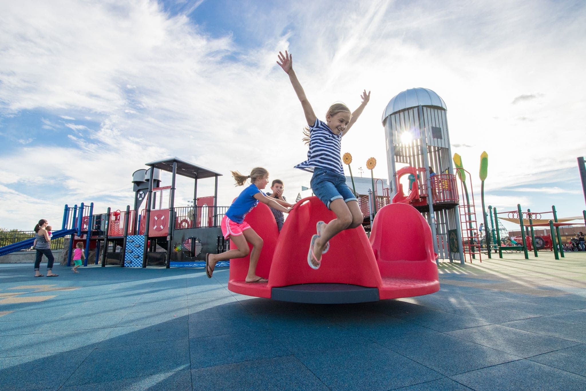 Pour-in-place rubber safety surfacing laid in bright colours beneath playground equipment